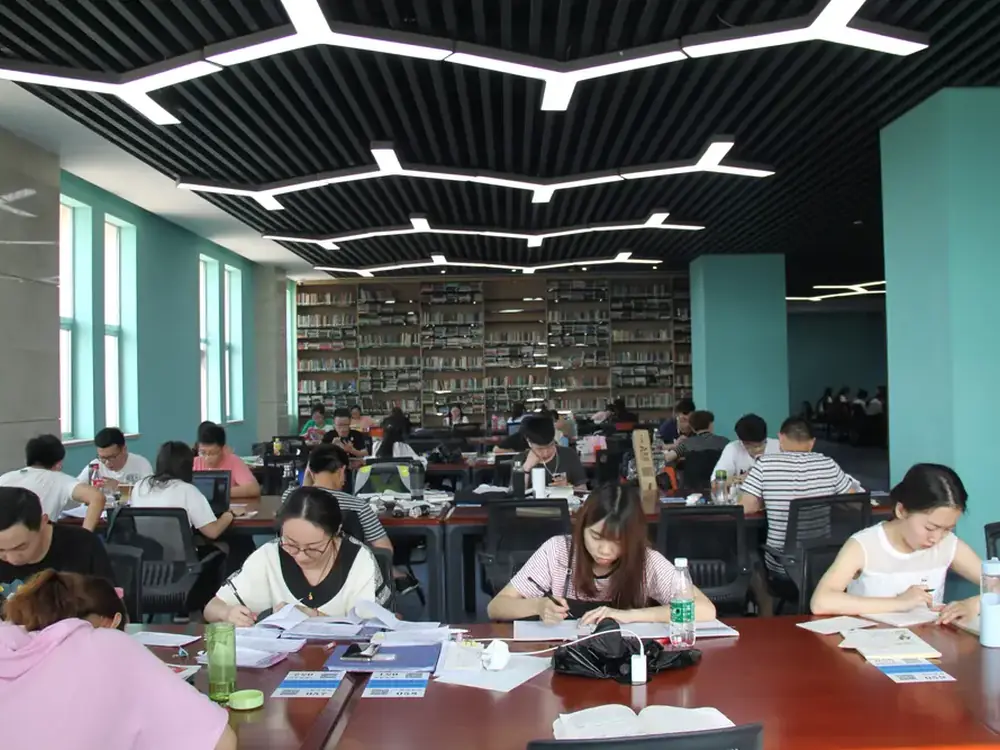 Multiple students studying at tables in a bright modern university library