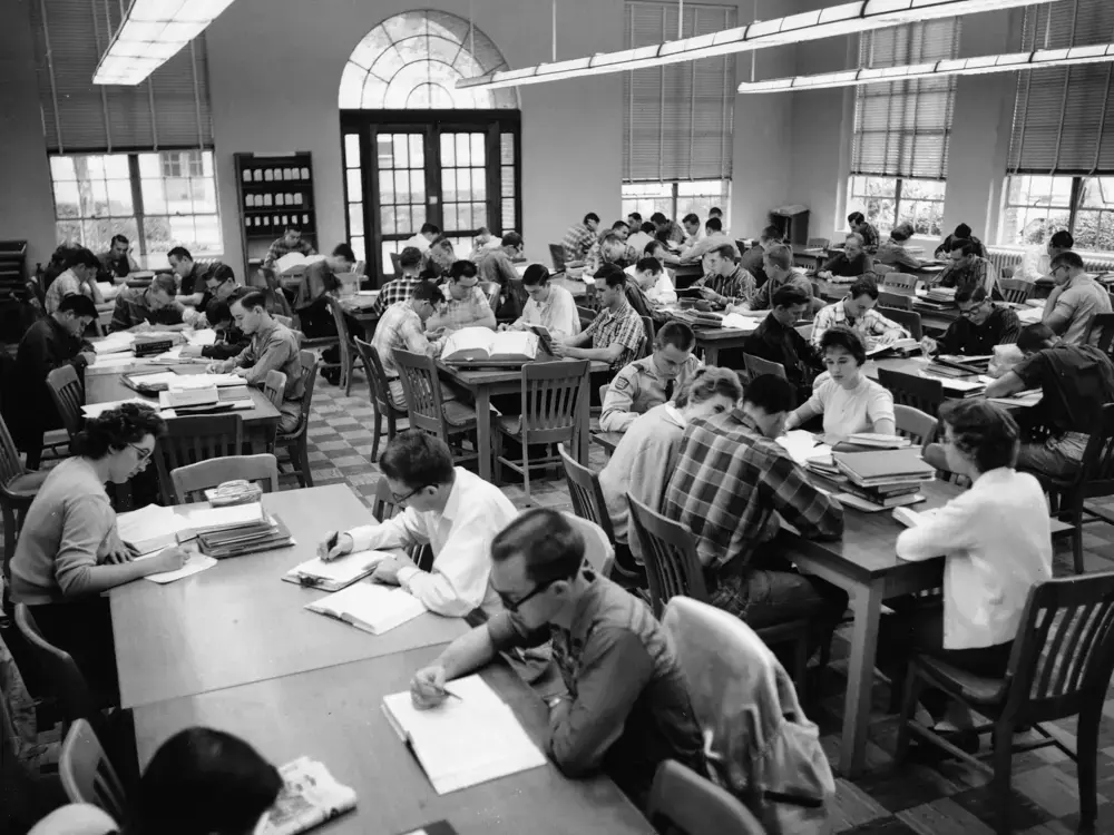 Group of students studying together in a classic university library